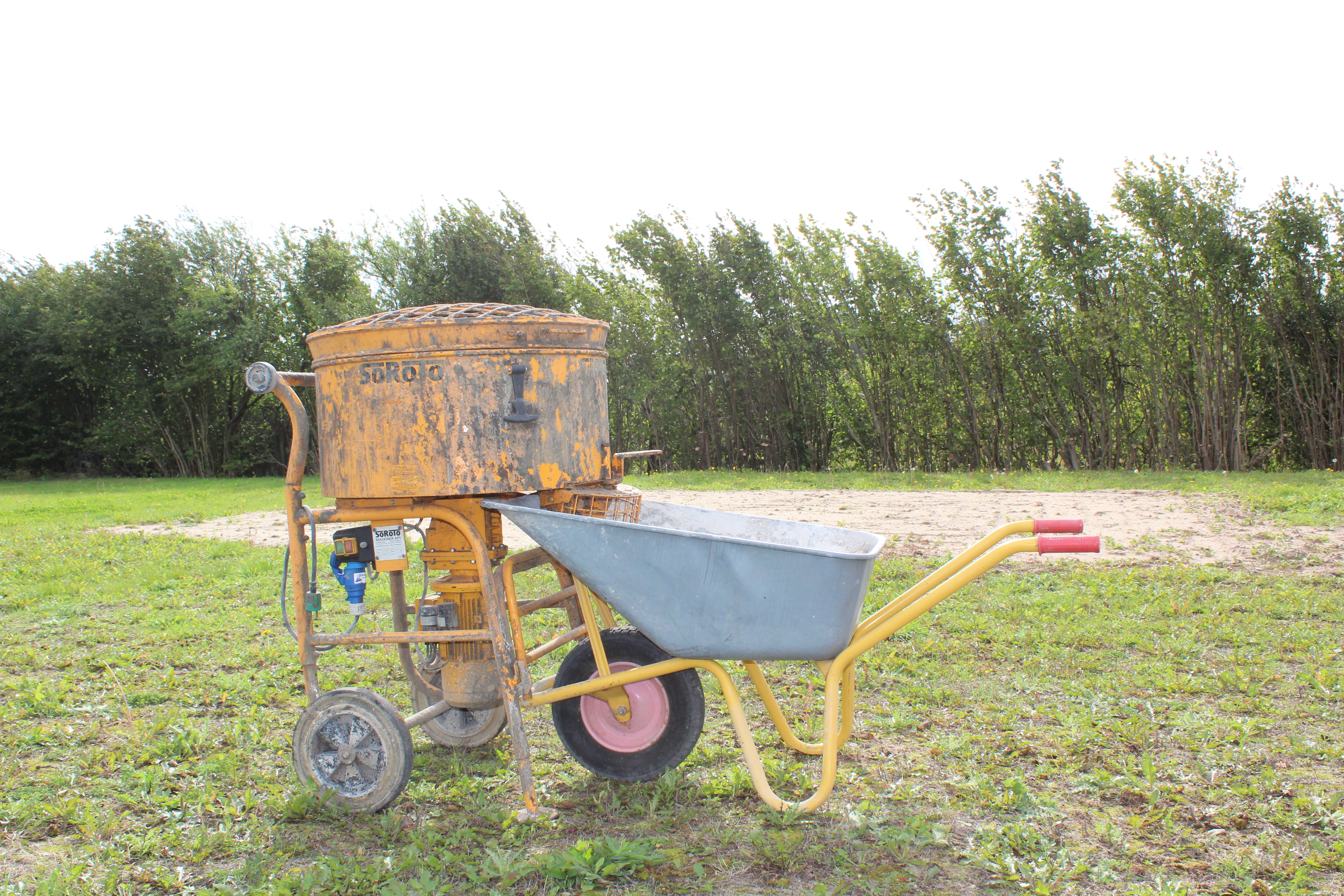 Eight shirts arranged on table in black, olive, grey, blue, white, red, mustard, and green.