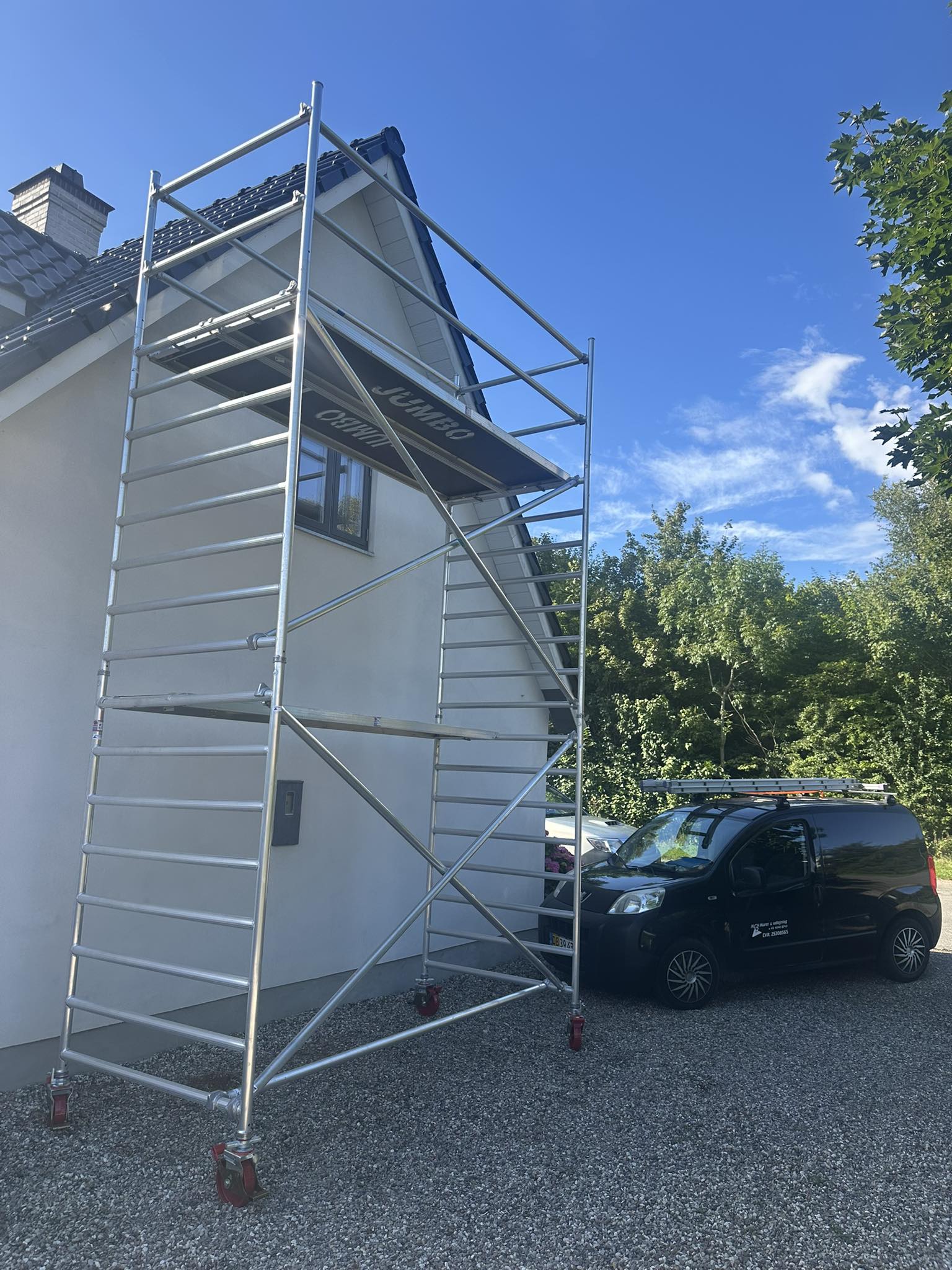 Eight shirts arranged on table in black, olive, grey, blue, white, red, mustard, and green.