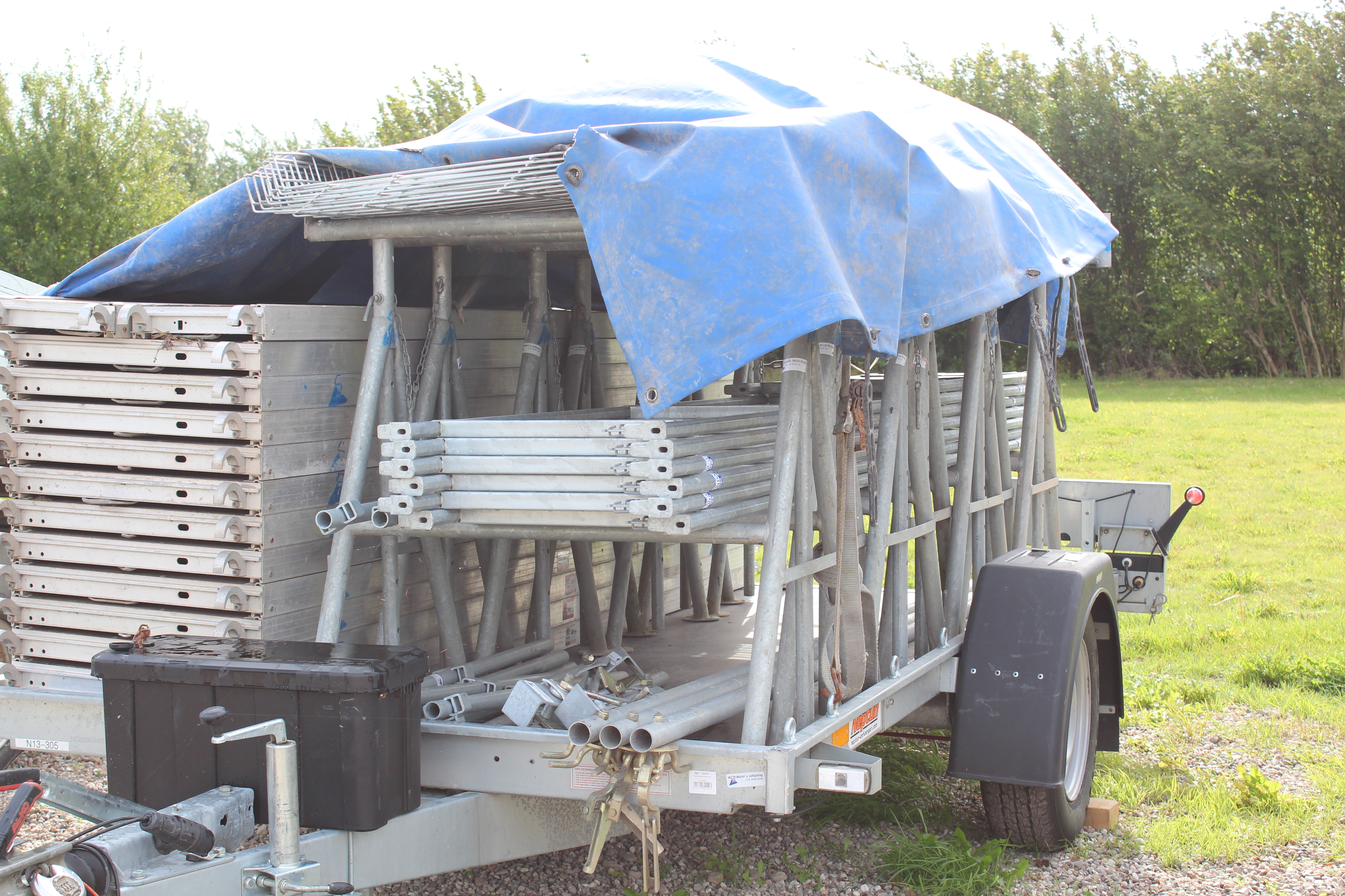 Eight shirts arranged on table in black, olive, grey, blue, white, red, mustard, and green.