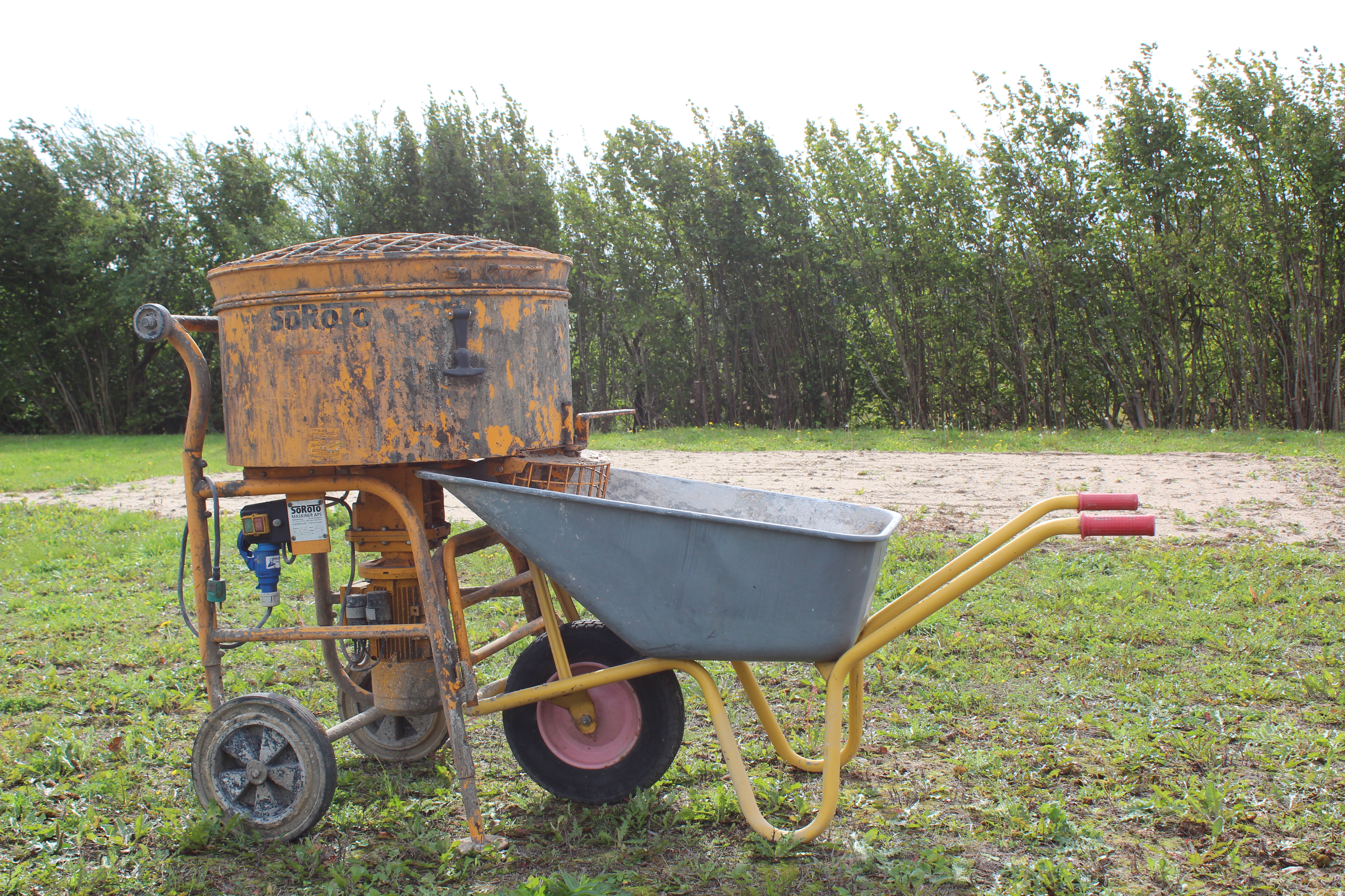Eight shirts arranged on table in black, olive, grey, blue, white, red, mustard, and green.