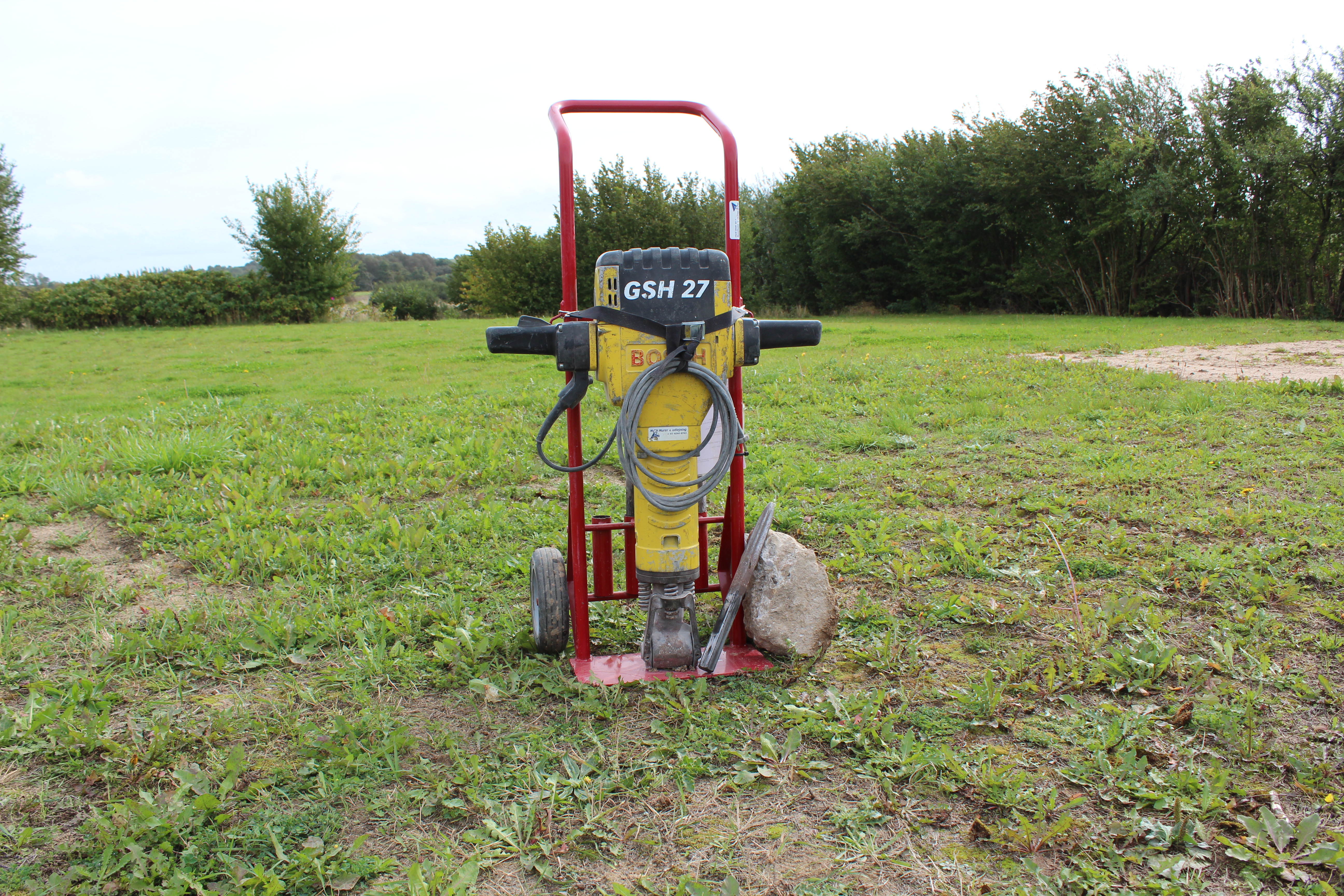 Eight shirts arranged on table in black, olive, grey, blue, white, red, mustard, and green.